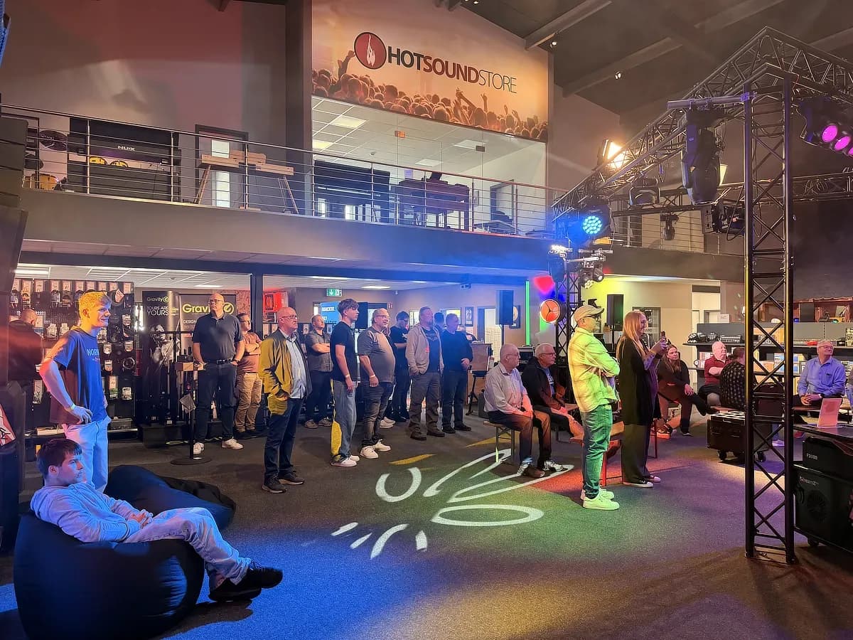 Besucher und DJ-Material im beleuchteten HotSound Store mit Bühne und Tresen